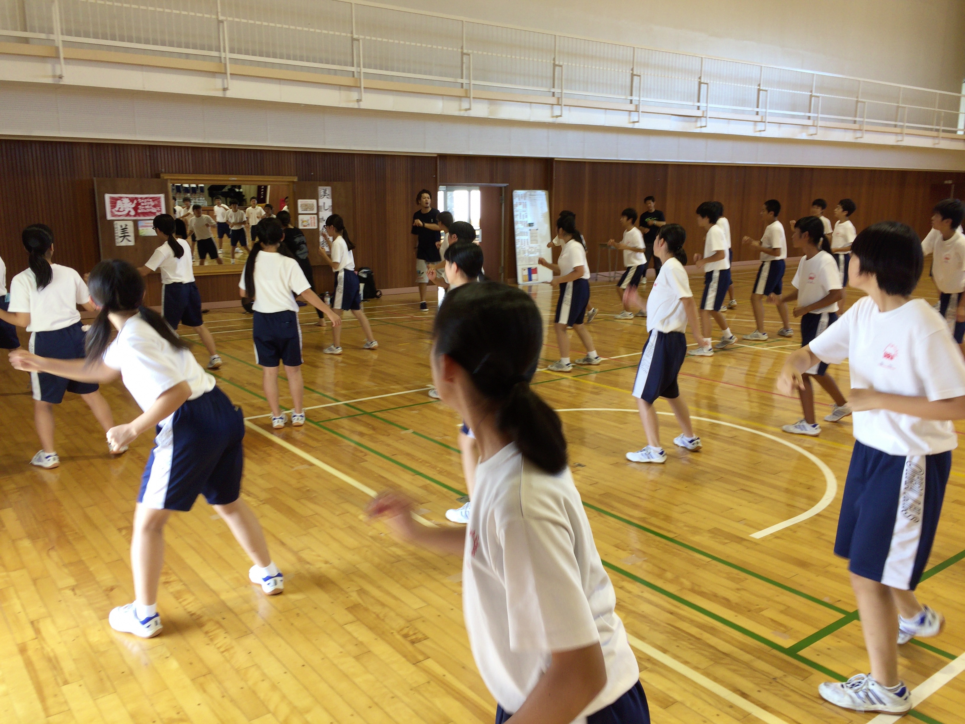 中学生がダンスを習って踊っている様子